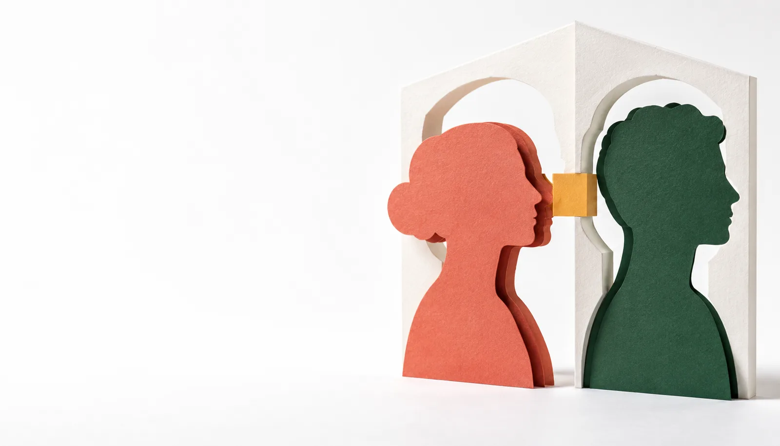 Layered coral and green paper profiles aligned with cut-out outlines in a white sculptural frame